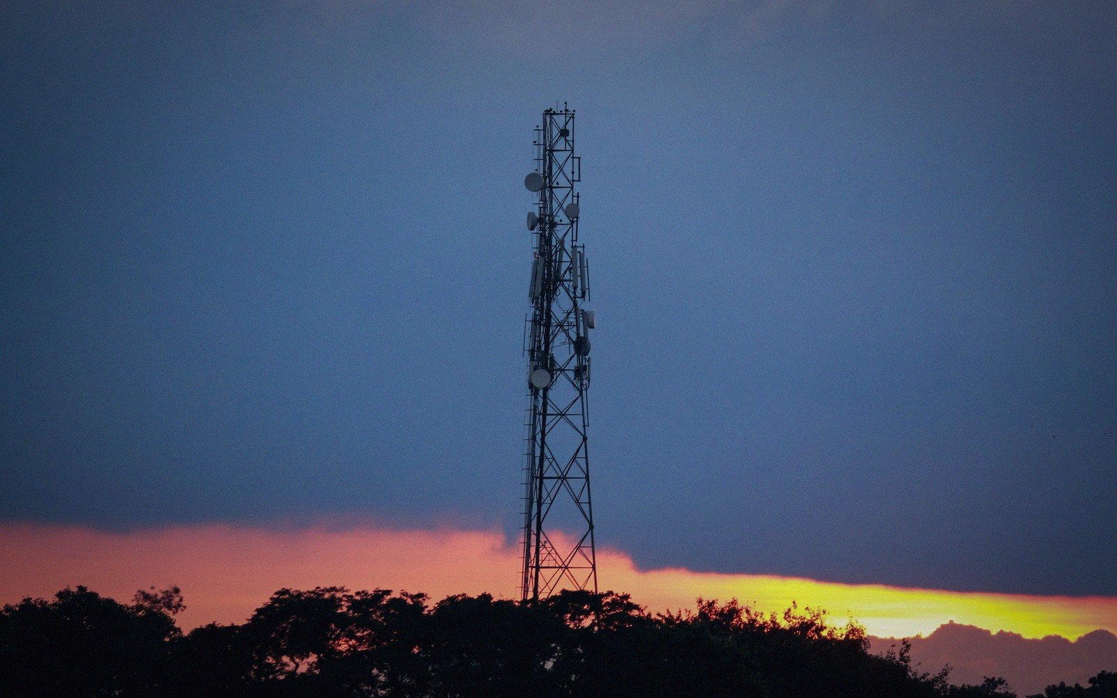 a lattice transmitter mast against the evening sky